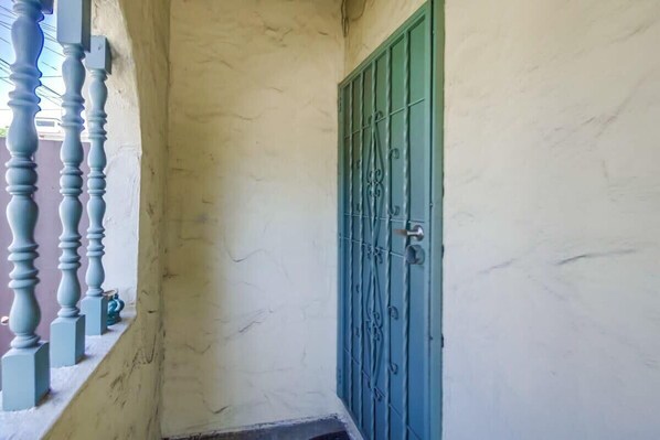 A narrow corridor with a blue door and a white wall.