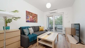 Een moderne woonkamer met een bank, salontafel en televisie.