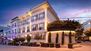 Un hotel de varios pisos con estilo arquitectónico europeo clásico, con balcones y una fachada bien iluminada.