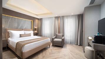 Una habitación de hotel moderna con una cama grande, un escritorio y una silla.
