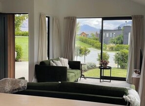 Relax on the balcony with a view of the garden and a building in the distance.