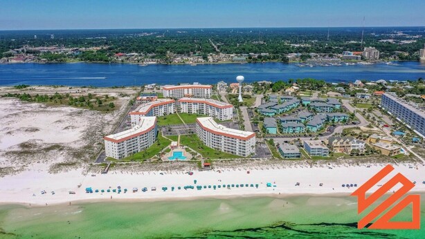 Ein Küstenhotel mit mehreren Gebäuden, einem Strand und einer Marina.