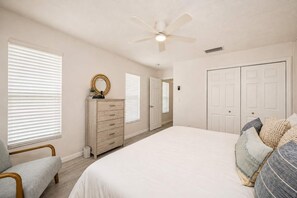 A bedroom with a bed, a dresser, a chair, and a ceiling fan. - Dog-Friendly • Pool & Boat Dock • Sombrero Beach (Marathon)