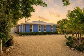 A single-story building with a blue facade and a gravel driveway. - Dog-Friendly • Pool & Boat Dock • Sombrero Beach (Marathon)