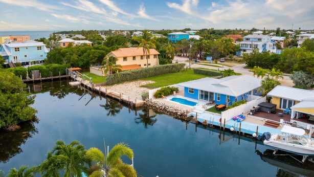 A residential area with houses, a dock, and a calm water body. - Dog-Friendly • Pool & Boat Dock • Sombrero Beach (Marathon)