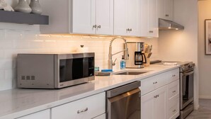 A modern kitchen with white cabinetry, stainless steel appliances, and a built-in dishwasher. - Dog-Friendly • Pool & Boat Dock • Sombrero Beach (Marathon)