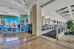 A modern hotel lobby with a reception desk, a Sky Bar, and a staircase.