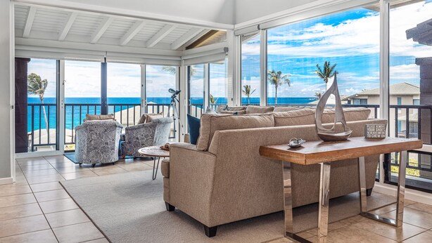 A spacious living room with a large window overlooking the ocean, a sofa, two armchairs, and a wooden coffee table. - Contemporary cool with endless Ocean views (Lahaina)