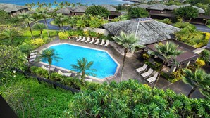 A resort with a pool surrounded by lounge chairs, palm trees, and ocean views. - Contemporary cool with endless Ocean views (Lahaina)