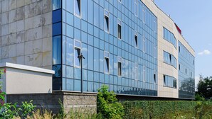 Un bâtiment moderne doté d’une façade en verre et de nombreuses fenêtres.