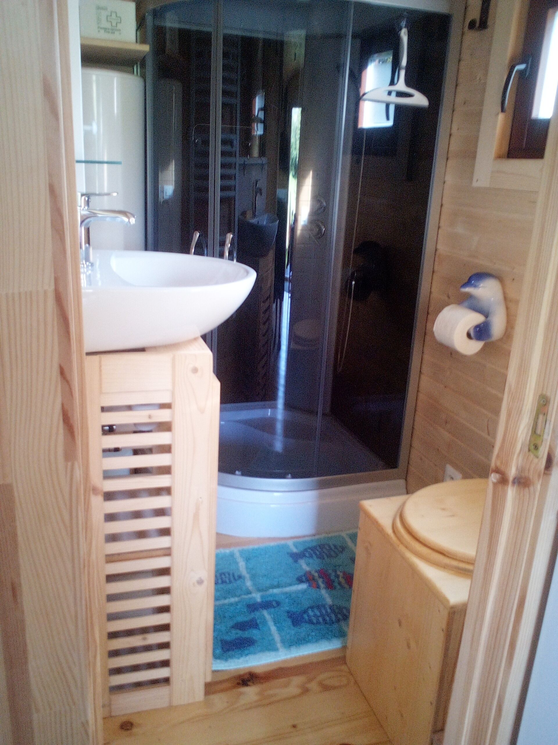 Een douche, handdoeken, zeep, toiletpapier