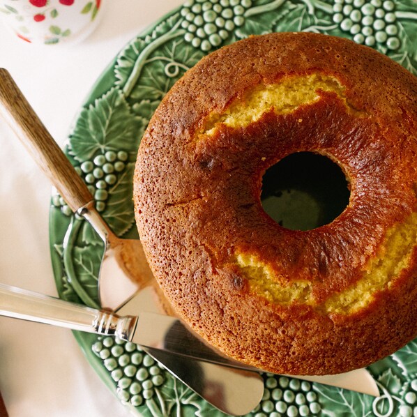 A bundt cake on a green plate with a knife. - Quinta Dona Matilde (Peso da Régua)