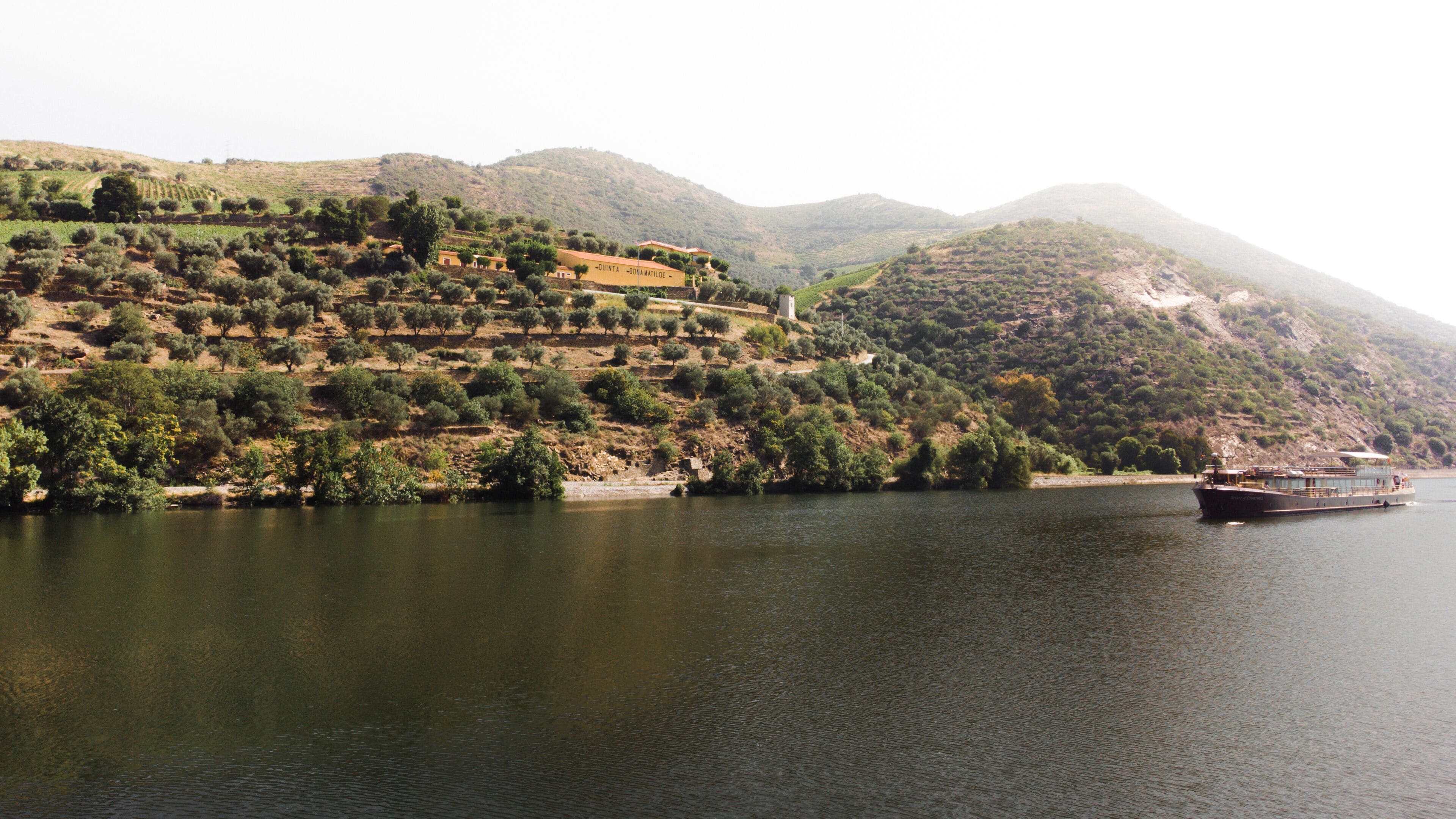 Un bote en un lago tranquilo con un paisaje montañoso al fondo.