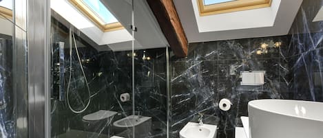 Un baño moderno con tragaluz, un bidé, un inodoro y una bañera grande.