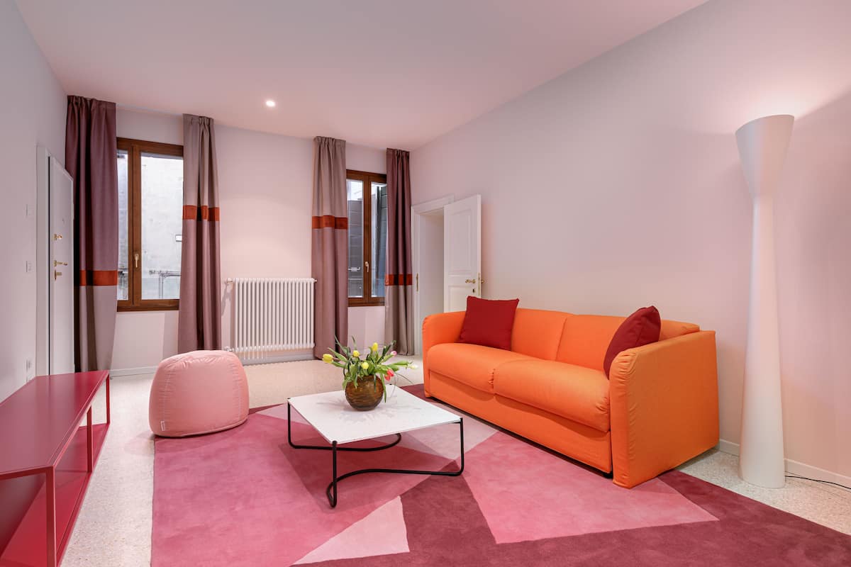 Una sala de estar moderna con un sofá, una mesa de centro y un sillón de peluche.