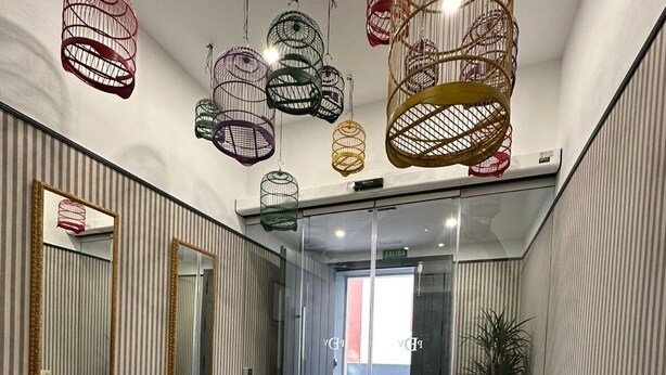 Un intérieur moderne avec un coin salon, un miroir et des luminaires suspendus.