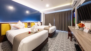A hotel room with two beds, a desk, and a TV. - Sino Siam Hotel (Krabi)