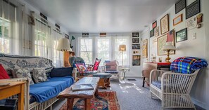 A cozy living room with a blue sofa, a wooden coffee table, and a wicker chair.
