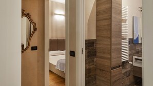 Habitación de hotel con cama, un espejo grande, un radiador y un panel de pared de madera.