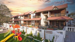 A multi-story hotel with balconies, a children's play area, and a well-maintained garden. - AR Thanga Kottai (Tirupattur)
