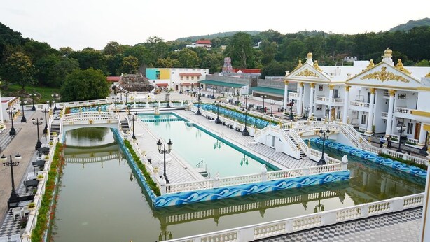 A large, rectangular pool with a central island, surrounded by ornate walkways and a bridge. - AR Thanga Kottai (Tirupattur)
