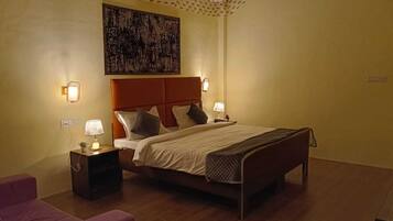 Habitación de hotel con cama, lámparas de noche, mesita de noche, una obra de arte en la pared y techo con diseño.