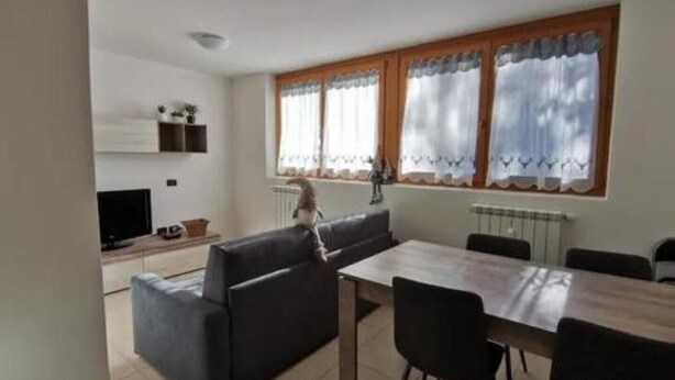Una cucina moderna con zona pranzo, comprensiva di divano, tavolo e sedie.