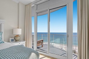 Enjoy a serene ocean view from the balcony, featuring a comfortable bed and stylish decor.