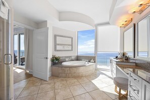 A modern bathroom with a freestanding bathtub, a large mirror, and a view of the ocean. - Penthouse unit with lagoon and gulf balconies! Check out the VIEWS Sleeps 16! (Gulf Shores)