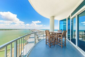 Enjoy ocean views from this spacious balcony with a round table and chairs.