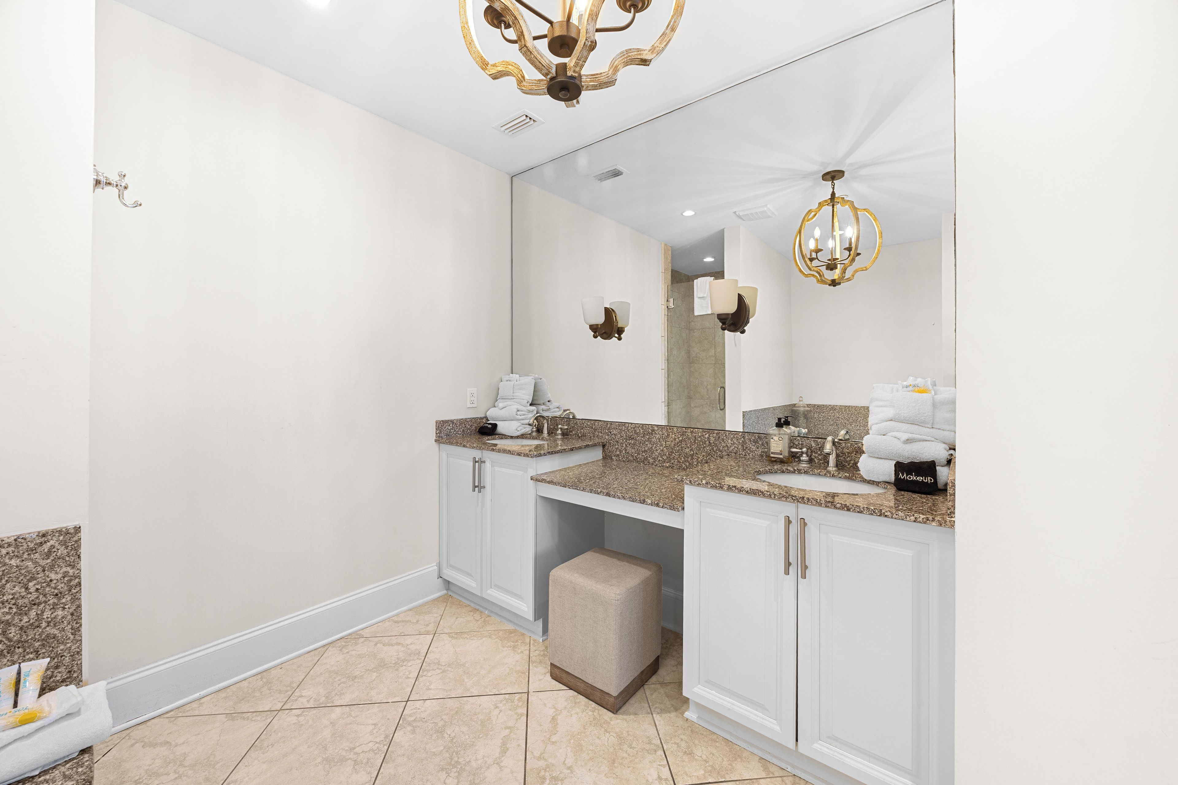 A modern bathroom with a large mirror, two sinks, and a vanity.