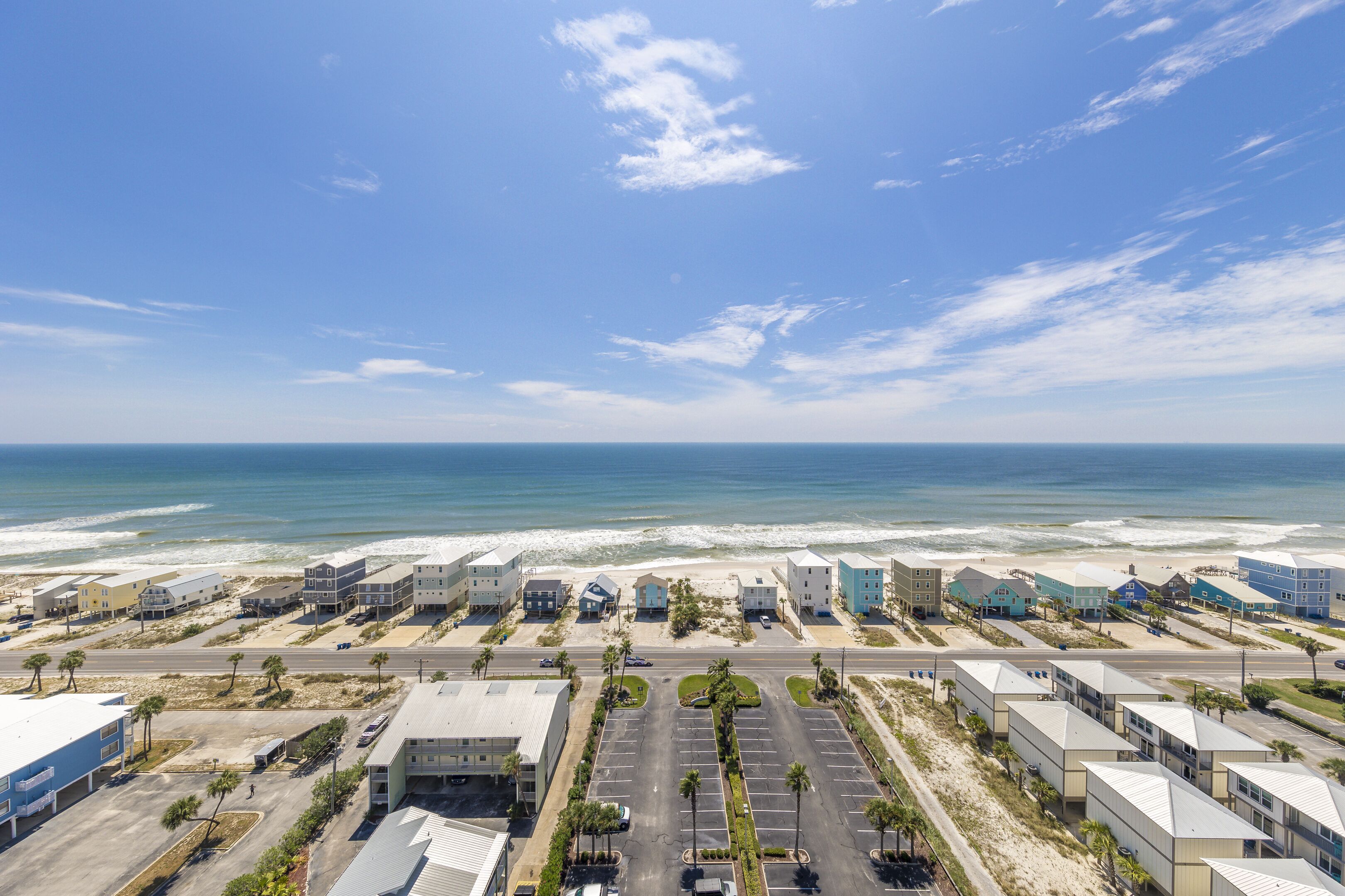 A coastal hotel with a parking lot, beach view, and ocean access.