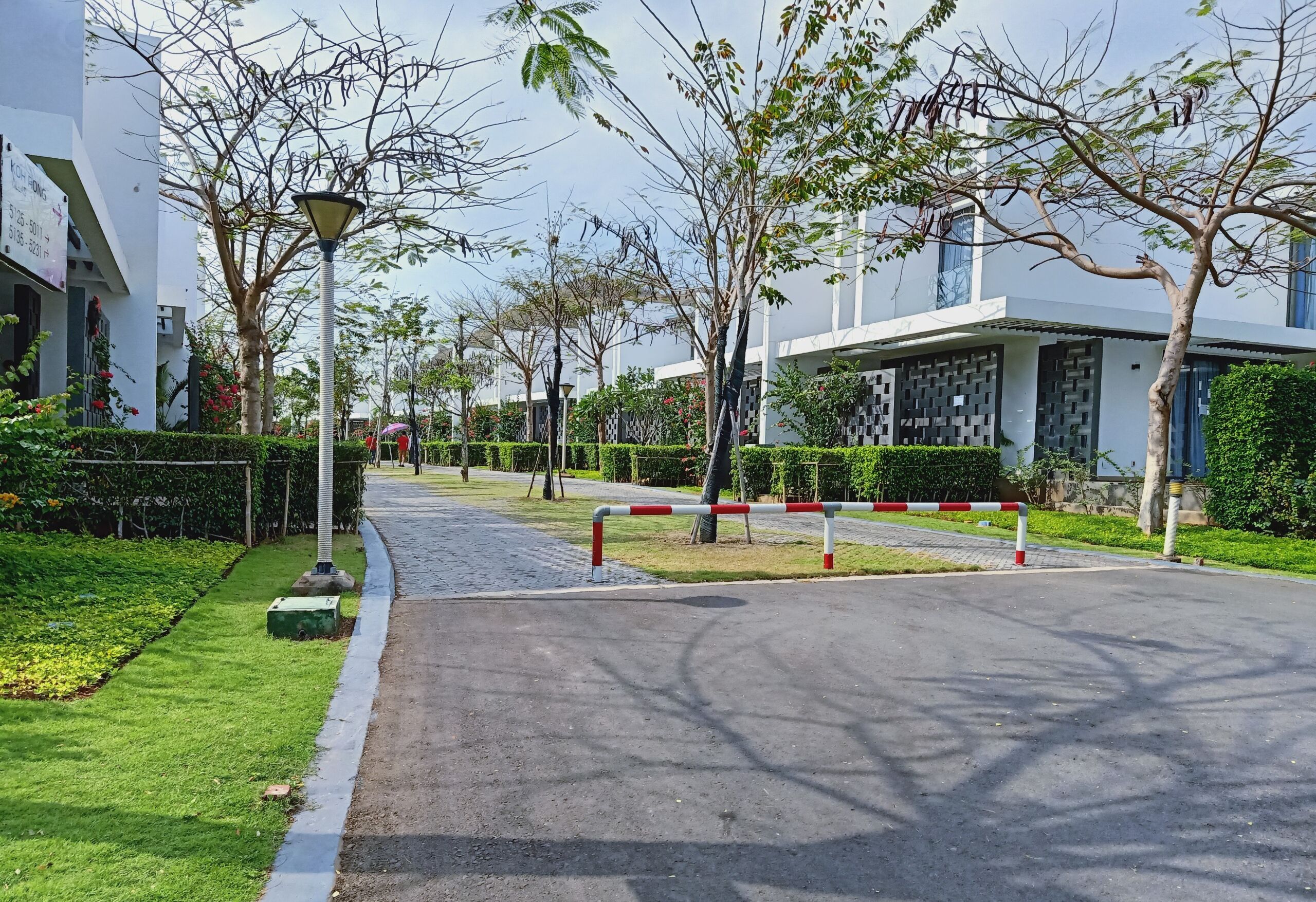 A pathway leading to a modern building with a clean, landscaped garden and a clear sky.