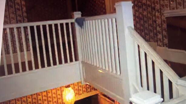 A staircase with white railings and a patterned wall. - Peace Apartment, upstairs with king size bed. (Anniston)