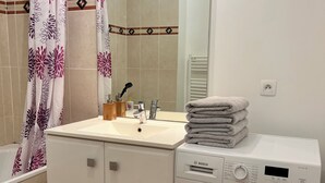 Ein Badezimmer mit Waschbecken, Spiegel und einer Bosch Waschmaschine.