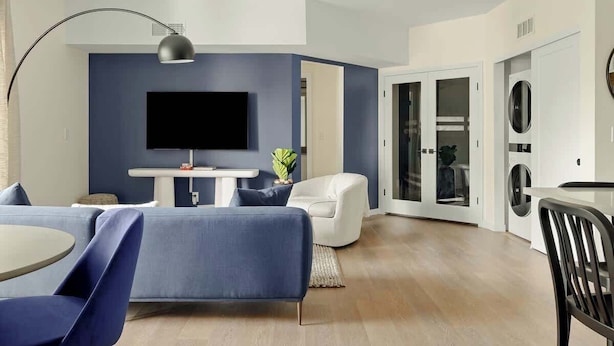 Un salon moderne avec un téléviseur à écran plat, un canapé, une table à manger et une chaise.