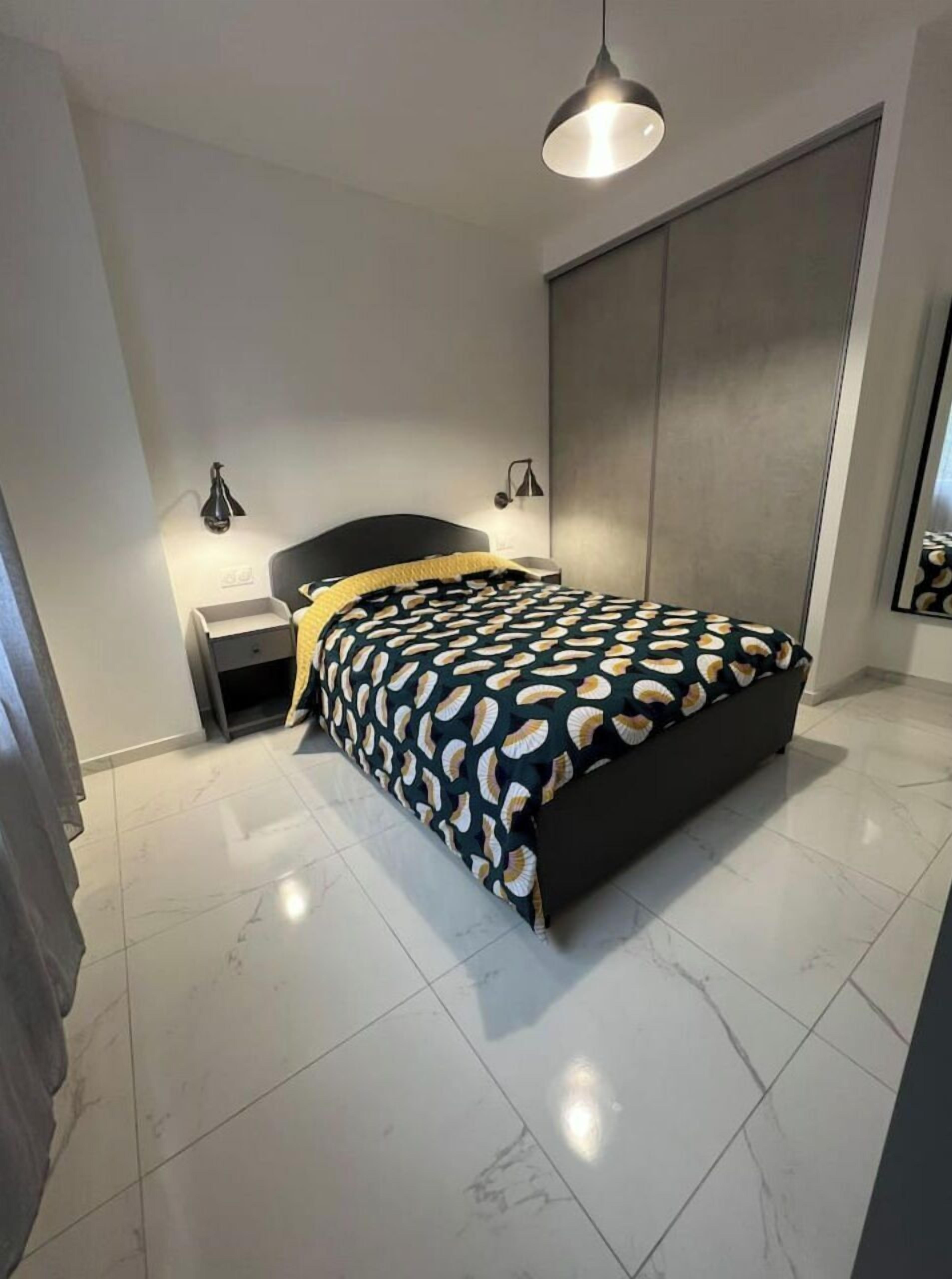 Une chambre à coucher moderne avec un lit, des tables de chevet et une grande armoire.