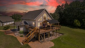 A two-story house with a deck, a satellite dish, and a garage.
