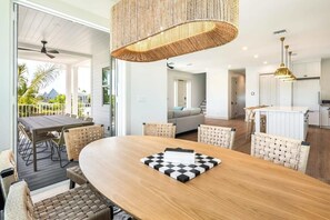 Ein modernes Interieur mit einem Holztisch, gewobenen Stühlen und einer karierten Tischmatte.