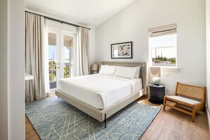 Une chambre à coucher comprenant un lit, une chaise, une table de chevet, une fenêtre et une vue sur l’extérieur.