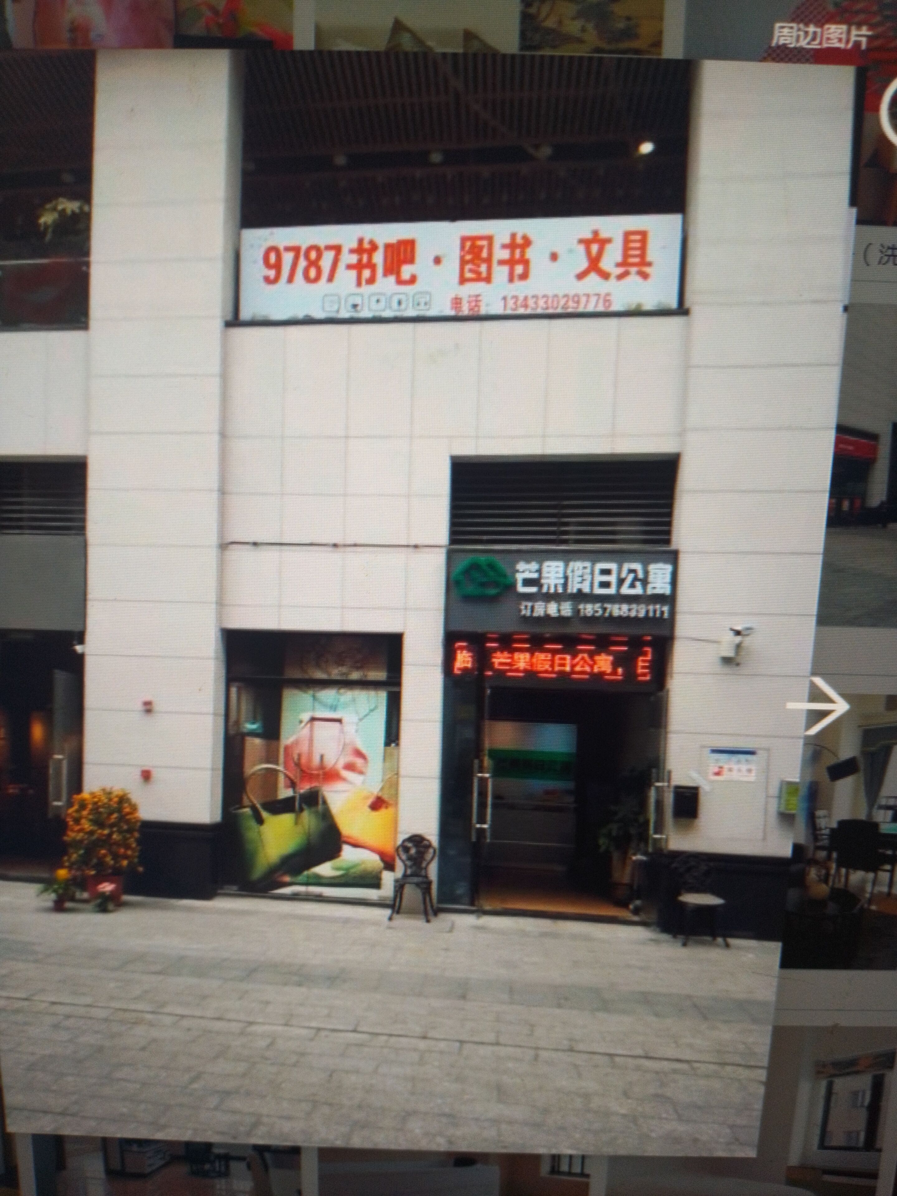 Ein Gebäude mit einer großen Schanze, die eine Buchhandlung bewirbt, und einem grünen Schild für ein Restaurant.