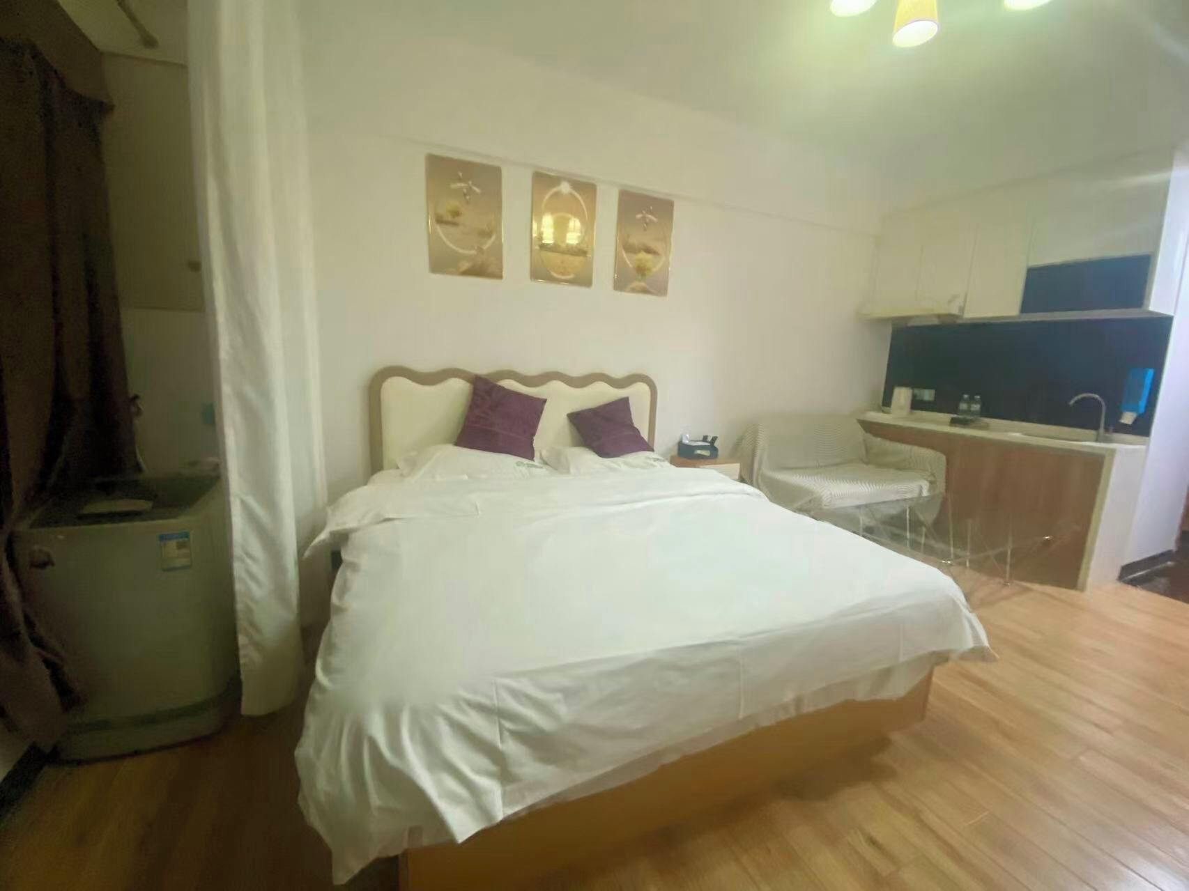 Una camera d'albergo con un letto, una scrivania, una sedia e un angolo cottura.
