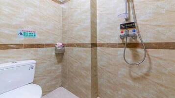 Een badkamer met een toilet, een douche en een bordje aan de muur.