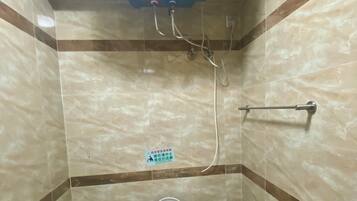 Ein kleines Badezimmer mit Toilette, Handtrockner und Wand-Klimaanlage.