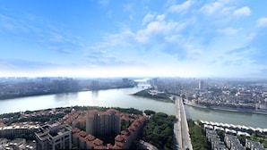A river with a bridge, a cityscape, and high-rise buildings. - ManGo Holiday Internation Apartment (Dongguan)