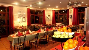A dining area with multiple tables set for a meal, featuring a fruit bowl and a bottle of wine. - Parking, tv, 55m², Saint Lary Soulan (Saint-Lary-Soulan)