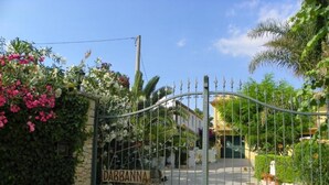 A gated entrance with a stone wall and a sign reading "DABBANNA". - Dabbanna home (Chiaramonte Gulfi)