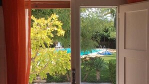 A room with a sliding glass door leading to a backyard with a pool and greenery. - Dabbanna home (Chiaramonte Gulfi)
