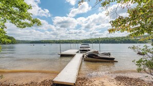A dock extending into a calm lake with boats moored at the end. - Secluded Lake Escape w/ Dock, Fire Pit & Views (Oakland)