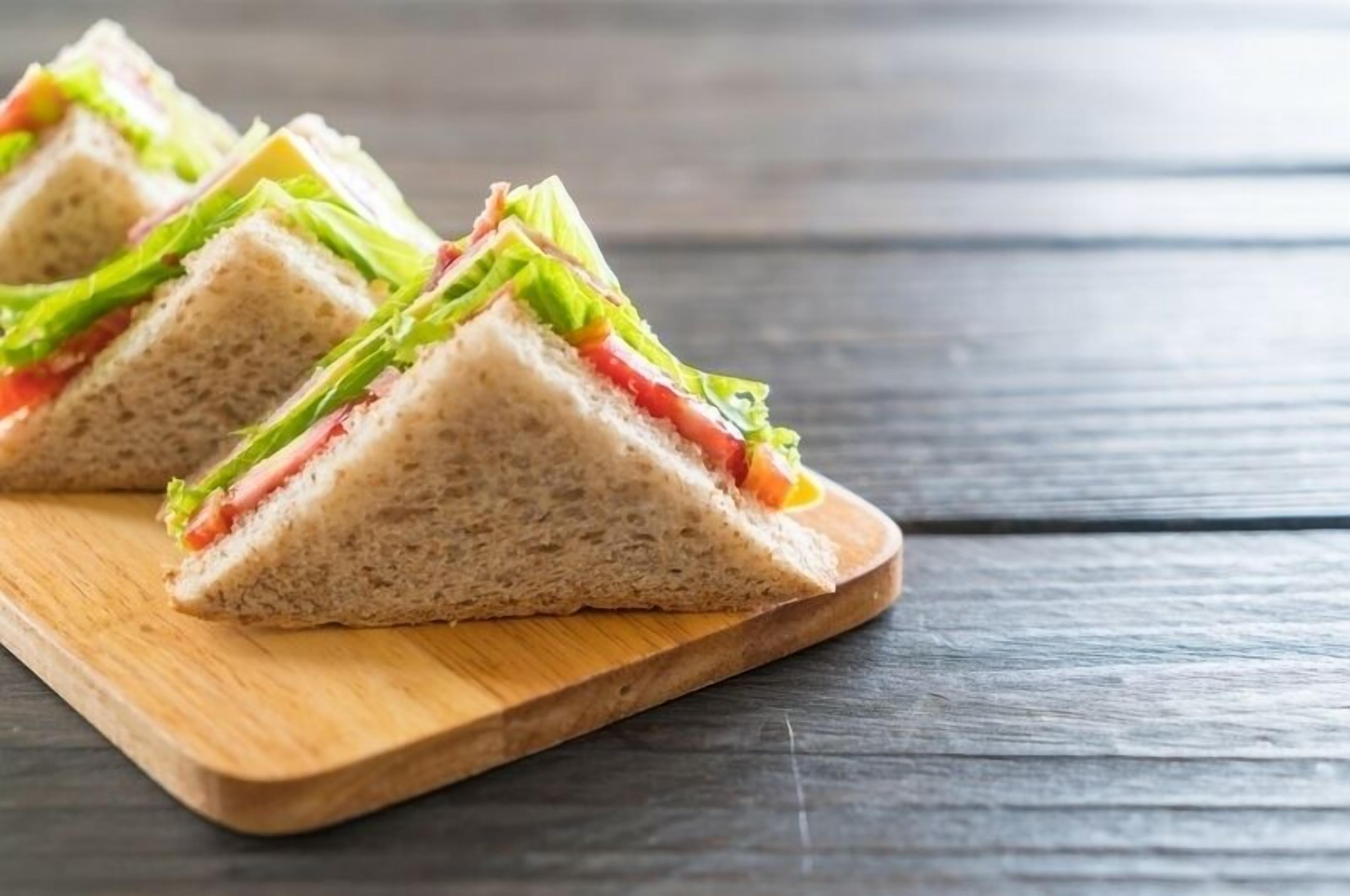 A sandwich on a wooden board.